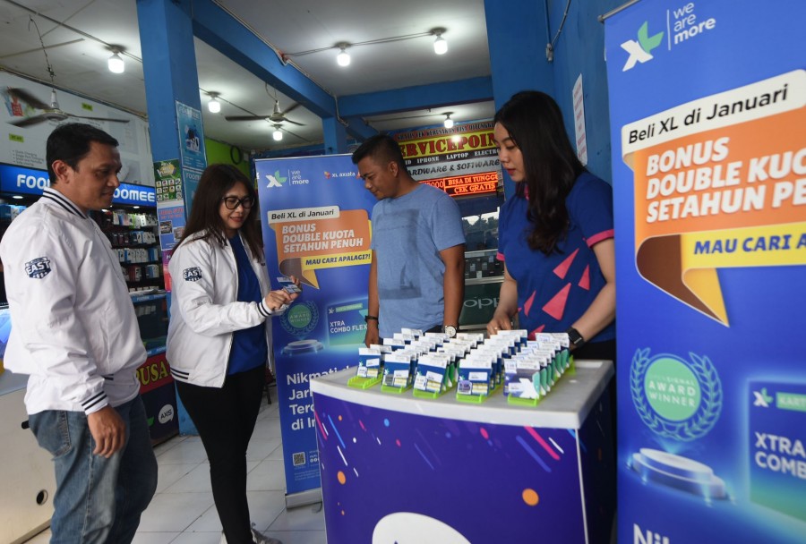 Dari kiri: Marketing Intelligence XL Axiata East Region Yoyok Nurhadi, Head Of Sales XL Axiata area Surabaya Madura Hiasinta H. Paembonan, bersama Pemilik Retail Outlet Redjo Cell.
